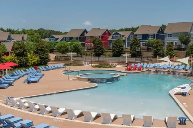 Pool area with many lounge chairs and houses exterior at College Town Oxford in Oxford Student Accommodation