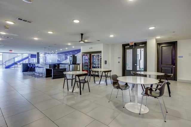 Round tables chairs and vending machines common area at Ion Baton Rouge in Baton Rouge Student Accommodation