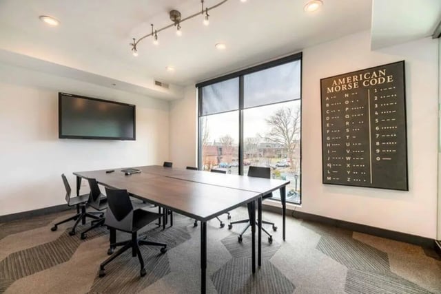 Table chairs large window TV Morse code board study area at T-H-E Griff in Columbus Student Accommodation