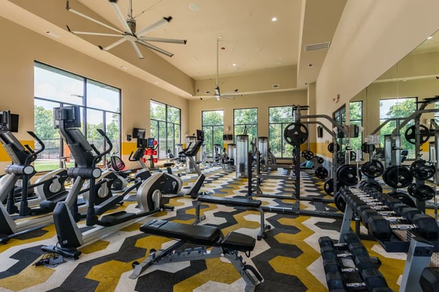 Gym with ellipticals treadmills weights and mirrors gym at The Quarters at Stillwater in Stillwater Student Accommodation