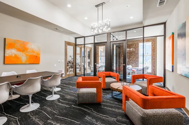 Modern lounge area with orange chairs and tables living room at The Quarters at Stillwater in Stillwater Student Accommodation