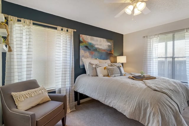 Bed artwork chair curtains blinds bedroom at The Landing at College Station in College Station Student Accommodation