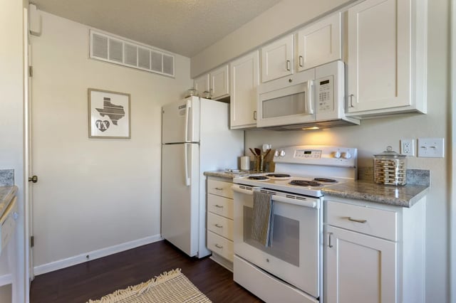 White appliances and cabinets in a studio kitchen at The Landing at College Station in College Station Student Accommodation