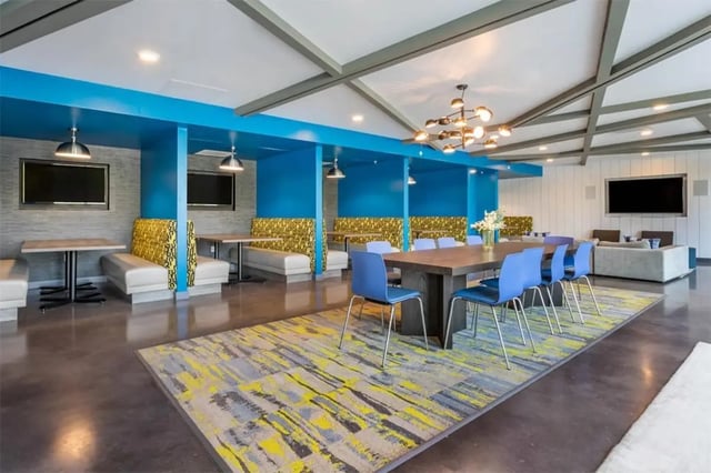 Dining tables booths lounge area and TVs common area at Rise At Riverfront Crossings in Iowa City Student Accommodation