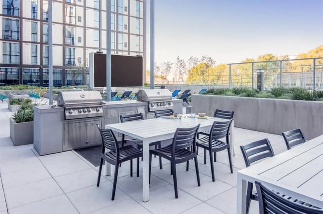 Outdoor grills table chairs patio area. at Rise At Riverfront Crossings in Iowa City Student Accommodation