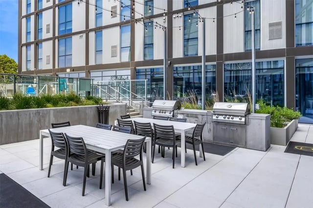 Outdoor dining tables grills and lounge area exterior at Rise At Riverfront Crossings in Iowa City Student Accommodation