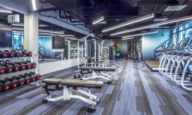 Dumbbells benches treadmills gym equipment workout room at Rise At Riverfront Crossings in Iowa City Student Accommodation