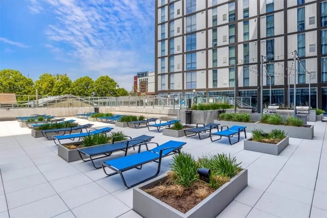 Blue lounge chairs on a rooftop patio exterior at Rise At Riverfront Crossings in Iowa City Student Accommodation