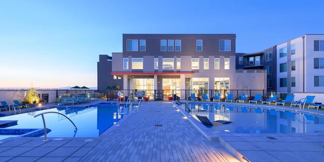 Swimming pool with lounge chairs building exterior at The Mark at Tucson in Tucson Student Accommodation