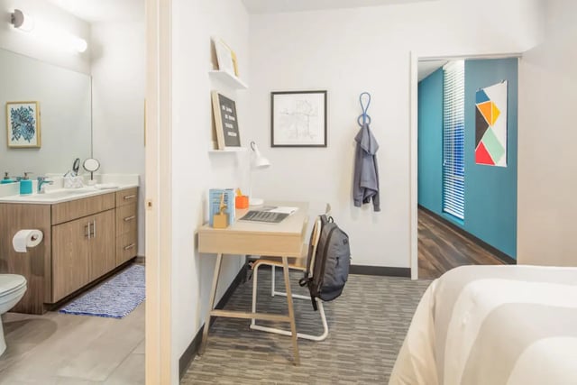 Desk with laptop and bathroom with toilet Bedroom study area at Rise On 9th in Columbia Student Accommodation
