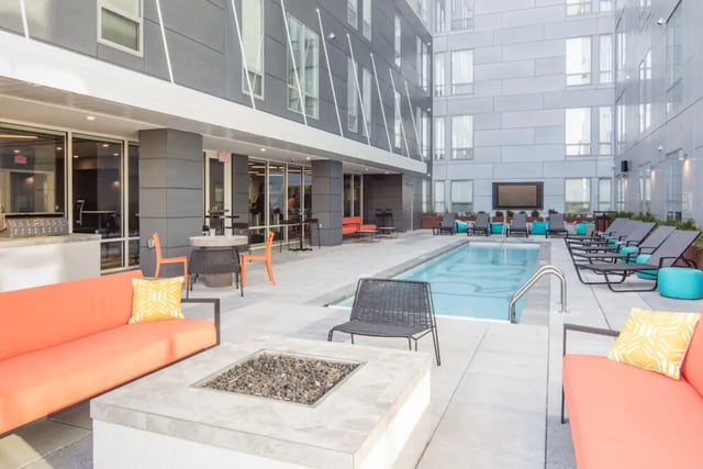 Orange couch pool fire pit lounge chairs exterior at Rise On Chauncey in West Lafayette Student Accommodation