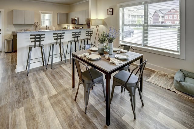 Dining table with place settings and kitchen counter bar living room at The Retreat at Denton in Denton Student Accommodation