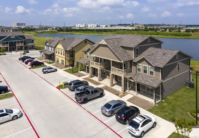 Apartments with parking lot and lake exterior at The Retreat at Denton in Denton Student Accommodation