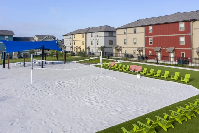 Volleyball court picnic tables blue shade green chairs exterior at The Retreat at Denton in Denton Student Accommodation