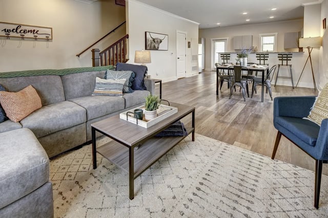 Gray sectional sofa coffee table dining area living room at The Retreat at Denton in Denton Student Accommodation