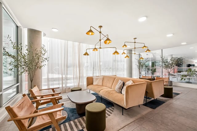 Modern lounge seating with tan sofa and chairs living room at Identity Davis Apartments in Davis Student Accommodation