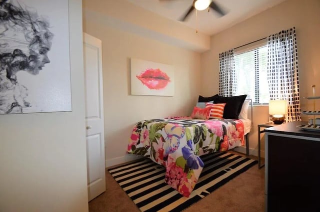 Bed with floral comforter lips art Bedroom at University Park in Boca Raton Student Accommodation