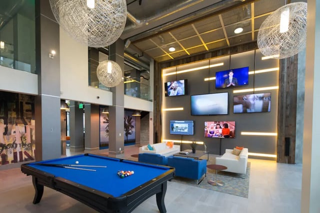 Pool table blue sofas lounge area wall screens lounge at University Park in Boca Raton Student Accommodation