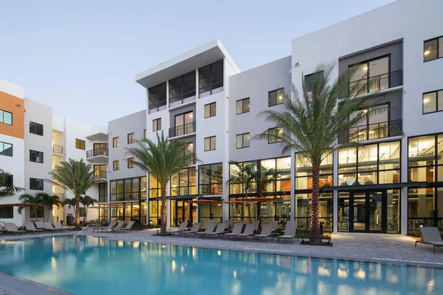 Modern building with pool and palm trees exterior at University Park in Boca Raton Student Accommodation