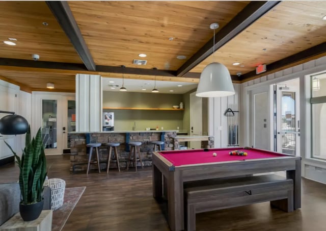 Pool table bar stools and kitchen area gaming room at Tradition at 777 in Baton Rouge Student Accommodation