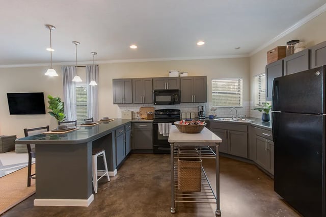 Gray cabinets kitchen island microwave and refrigerator kitchen at Ikon in Athens Student Accommodation