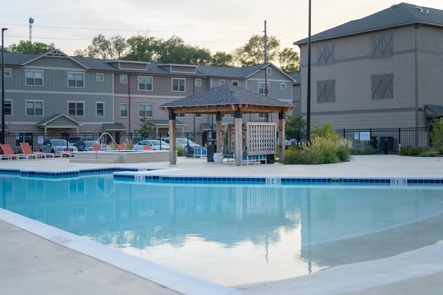 Pool lounge chairs gazebo apartment buildings exterior at The Retreat at Illinois in Urbana Student Accommodation
