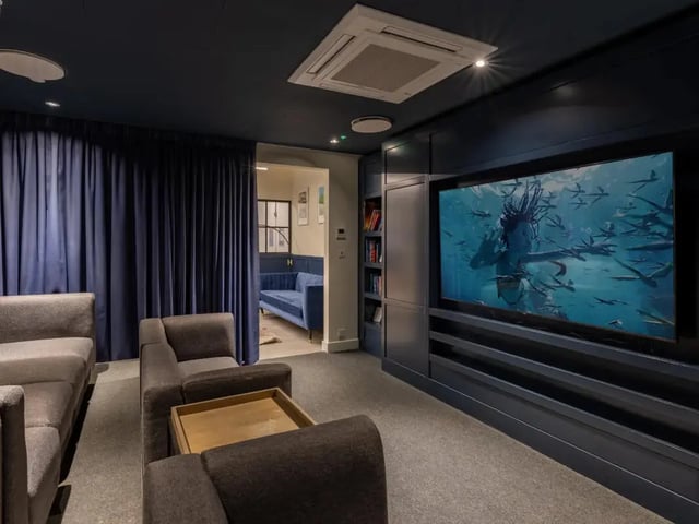 Sofas television bookshelves blue curtains living room at Great Court in London Student Accommodation