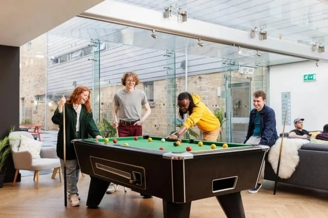 Students play billiards in a modern communal room at Sugarhouse in Edinburgh Student Accommodation