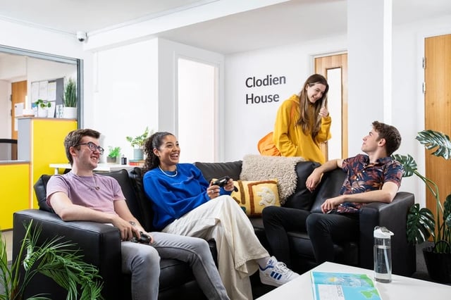 Students playing video games on couches living room at Clodien House in Cardiff Student Accommodation