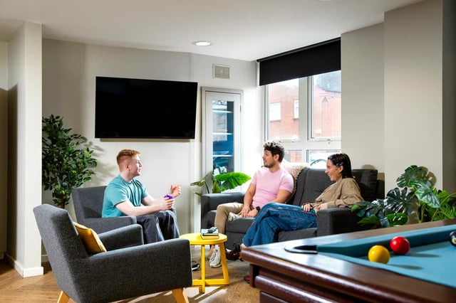 Students chatting by pool table and TV living area at Raglan House in Coventry Student Accommodation