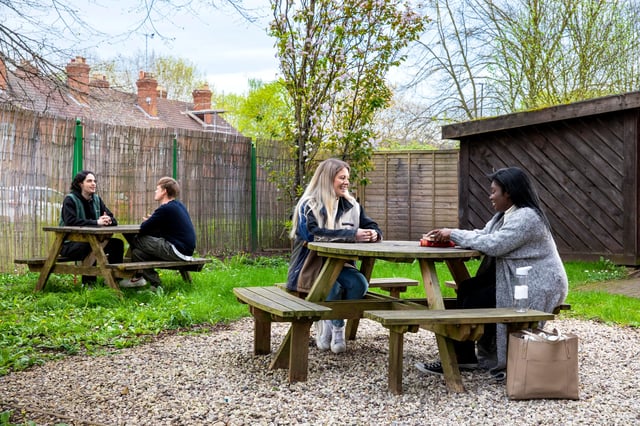 Students at picnic tables outdoors outdoor area at Raglan House in Coventry Student Accommodation