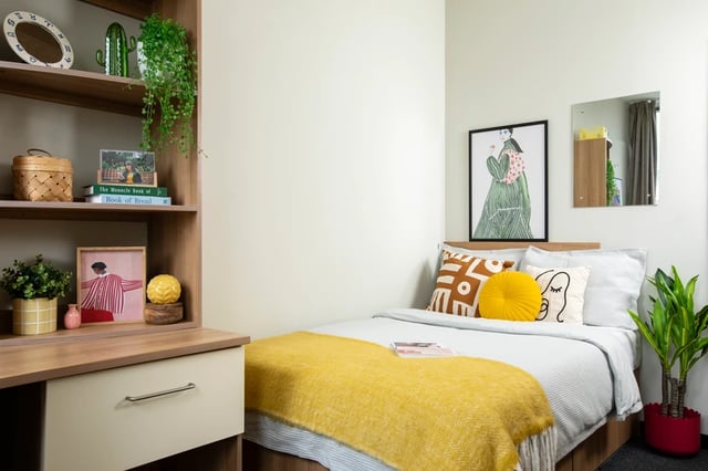 Bed with yellow throw and decor bedroom at Favell House in Bristol Student Accommodation