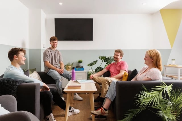 Four students on sofas near television living room at The Old Printworks in Edinburgh Student Accommodation