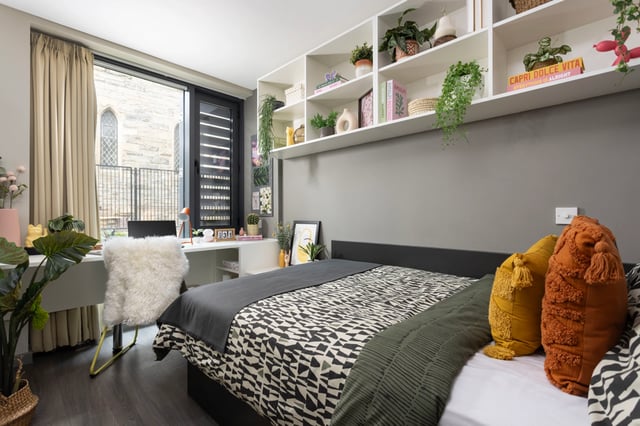 Bed with patterned duvet fluffy chair desk bedroom at Salisbury court in Edinburgh Student Accommodation