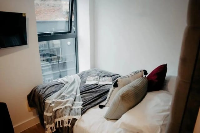 Bed with blankets pillows and open window bedroom at Volume Works in Birmingham Student Accommodation