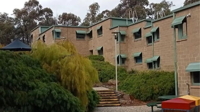 Brick building with awnings and trees exterior at La Trobe University - Units in Melbourne Student Accommodation