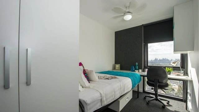 Bed desk chair closet with city view bedroom at UniLodge Victoria University in Melbourne Student Accommodation