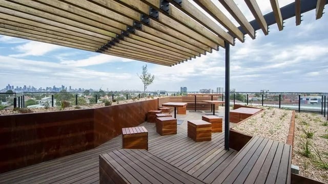 Wooden seating tables and planters rooftop deck exterior at UniLodge Victoria University in Melbourne Student Accommodation