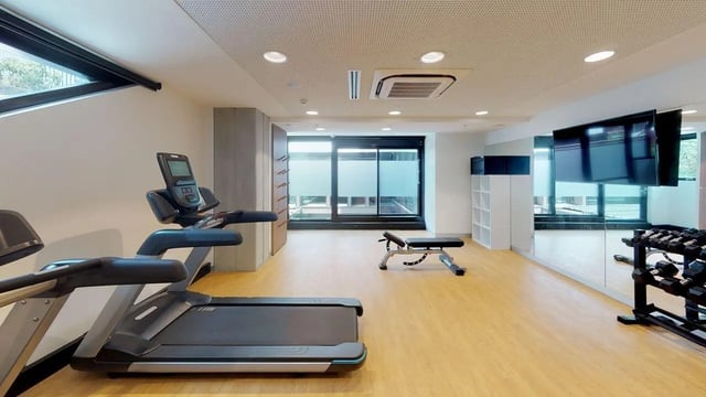 Treadmills bench dumbbells mirrored wall gym area at UniLodge Lincoln House in Melbourne Student Accommodation