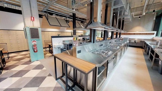 Multiple stoves sinks and lockers communal kitchen at UniLodge Lincoln House in Melbourne Student Accommodation