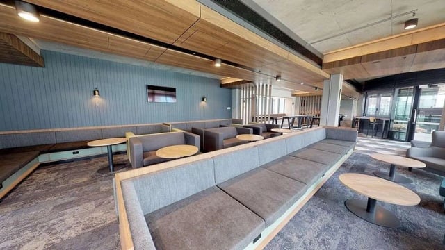 Modern communal lounge with grey sofas and tables at UniLodge Lincoln House in Melbourne Student Accommodation