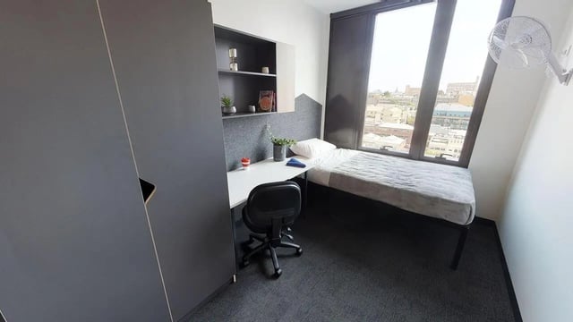Bed desk chair shelves and window bedroom at UniLodge Lincoln House in Melbourne Student Accommodation