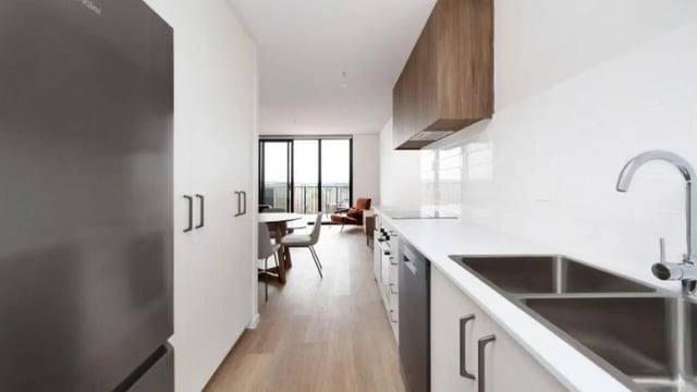 Modern kitchen with refrigerator dining table living room kitchen at Dickson Village Apartments in Canberra Student Accommodation