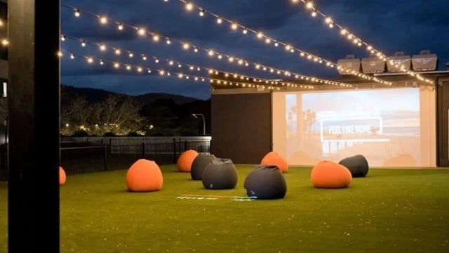 Beanbags outdoor cinema setup with string lights entertainment area at Dickson Village Apartments in Canberra Student Accommodation