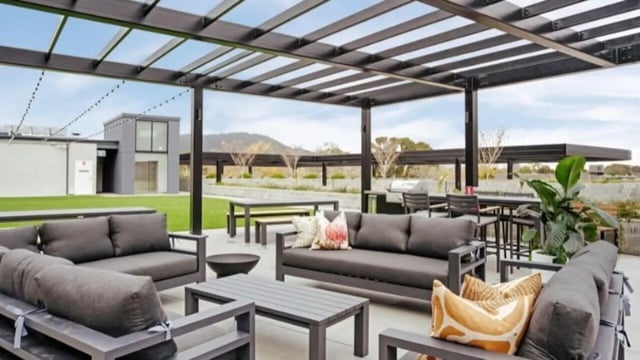 Outdoor seating and tables with pergola exterior at Dickson Village Apartments in Canberra Student Accommodation