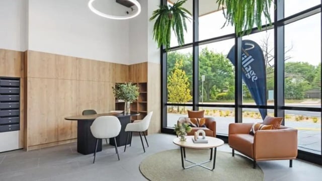 Wood paneling desk chairs couch and coffee table lobby at Dickson Village Apartments in Canberra Student Accommodation