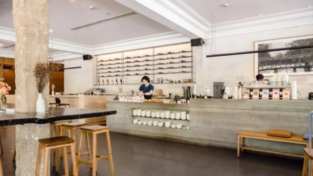 Barista behind counter with shelves of wine living room at Dickson Village Apartments in Canberra Student Accommodation
