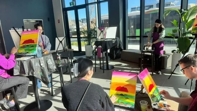 People painting colorful sunsets on canvases activity room at Dickson Village Apartments in Canberra Student Accommodation