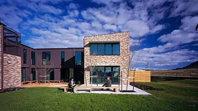 Two people on benches outdoors exterior at La Trobe University - McFarlane's Hill Residences in Wodonga Student Accommodation