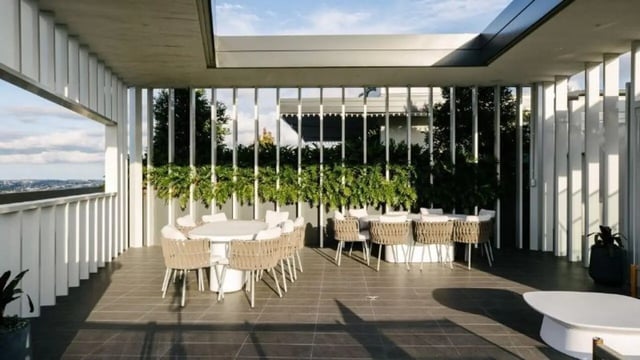 Outdoor dining tables with chairs and plants patio at Realm Kangaroo Point in Brisbane Student Accommodation